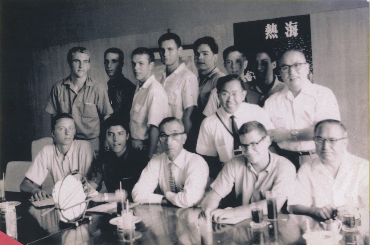 American teenage boys and Japanese hosts gathered around a table.
