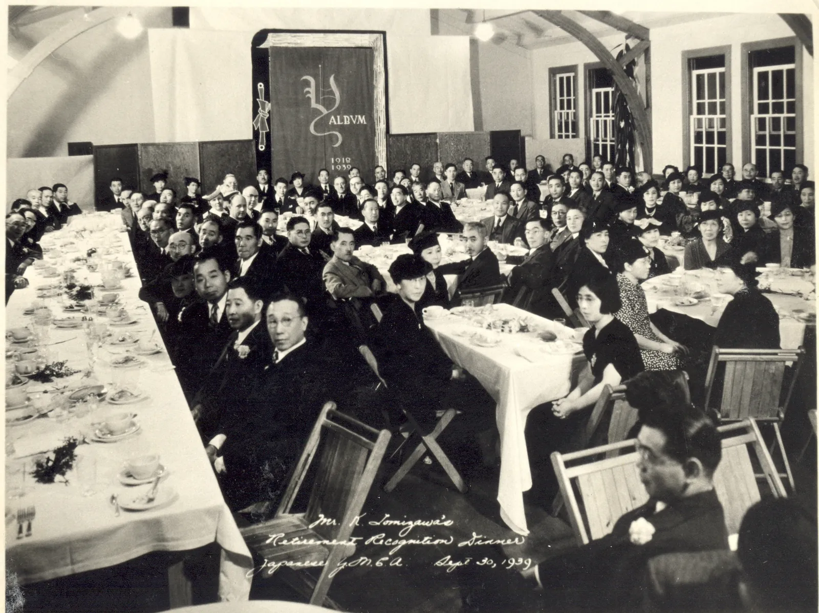 A banquet hall full of long tables and guests, with a banner reading “Y ALBUM 1918–1939”.