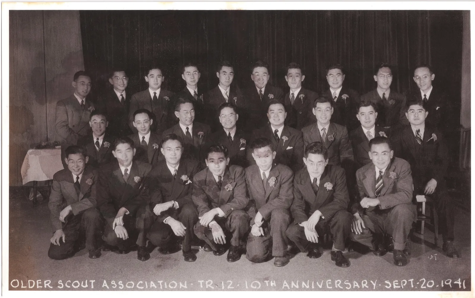 About thirty young men in suits with boutonnieres, in three rows; the caption reads “Older Scout Association, Tr. 12, 10th Anniversary, Sept. 20, 1941”.